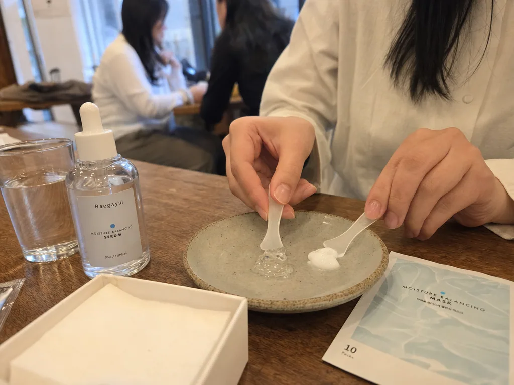 Clear and white skincare textures on a dish beside a Baegayul serum bottle and mask pack.