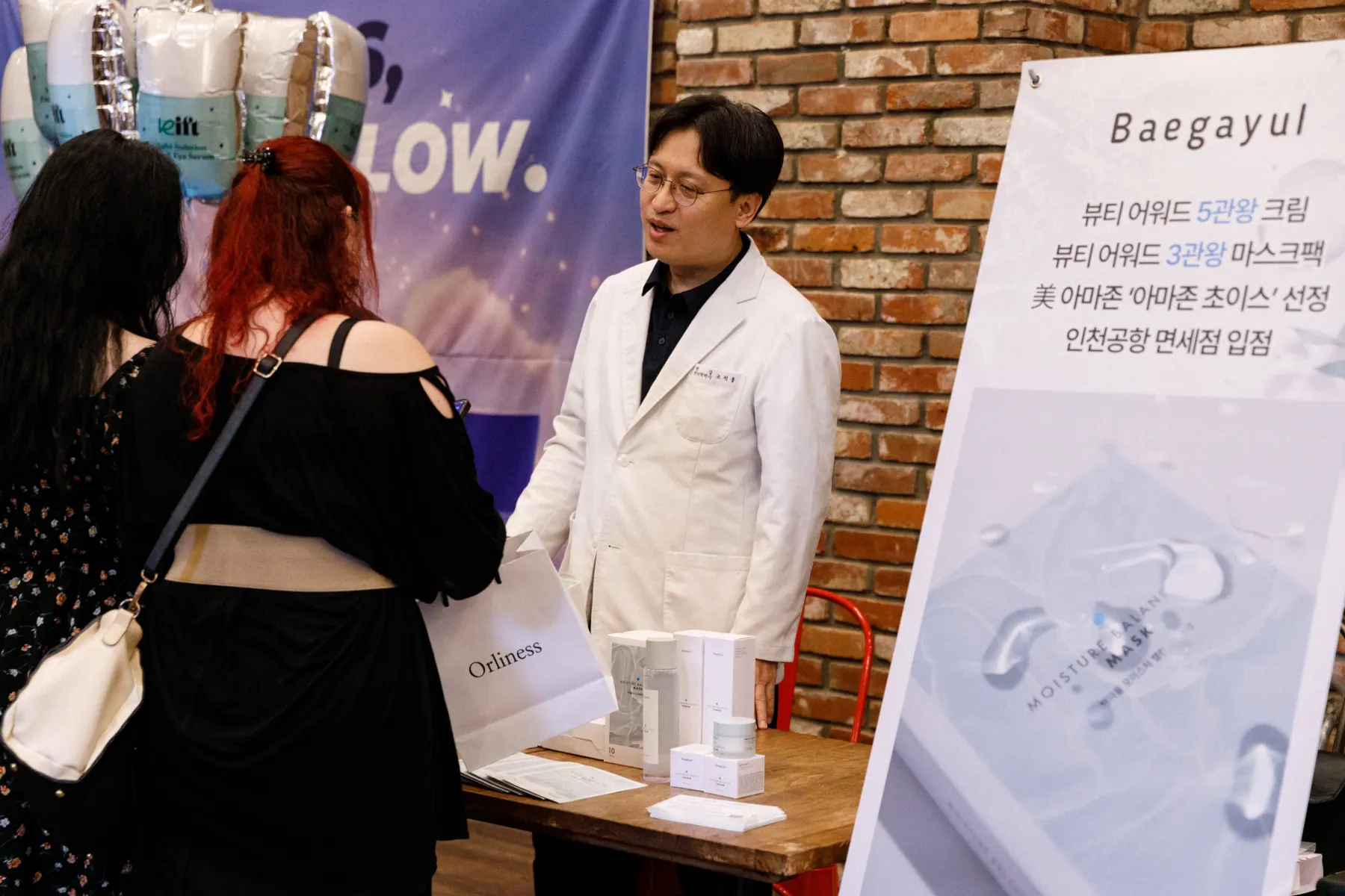 Dr. Jo Seok-yong speaking with guests beside a Baegayul display